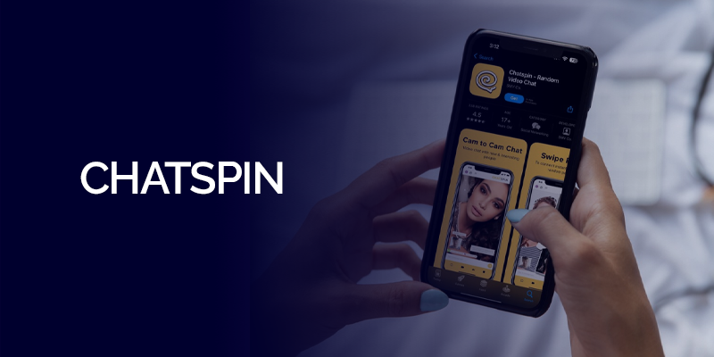 Person holding a smartphone displaying the Chatspin App's download page in appstore.