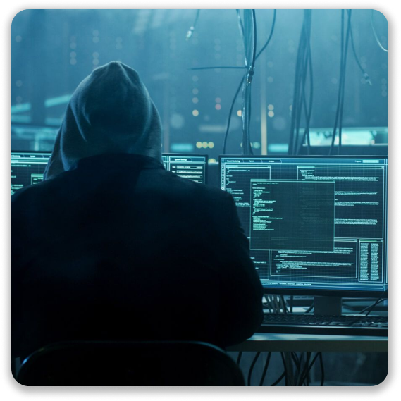 Image of a hacker facing multiple screens attempting to hack other user data and selling it on the Dark Web.
